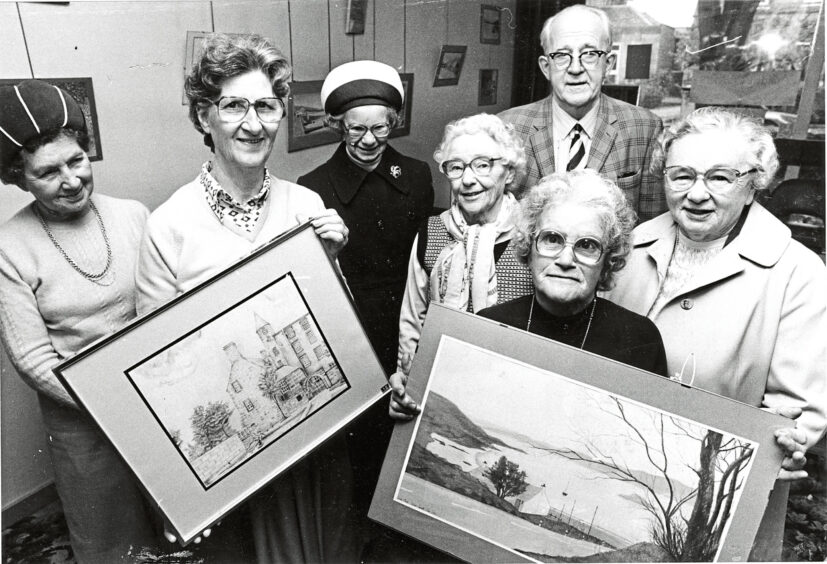 1985 - Showing off two of the pictures on exhibition at Queen’s Cross Church coffee lounge are members of the guild.