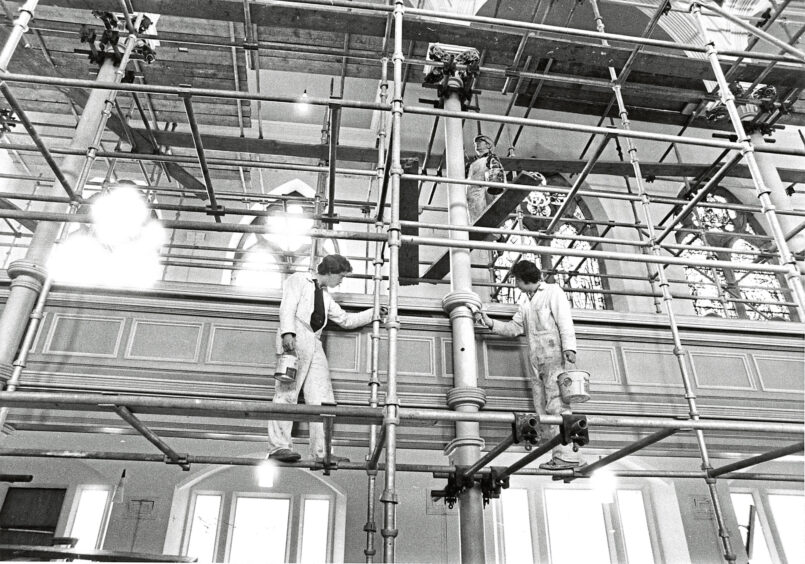 1980 - Scaffolding surrounds the interior of Queen’s Cross Church as Robert Vincent paints a decoration on one of the pillars.