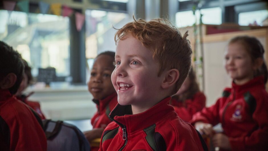 young pupil smiles during class in Albyn School, one of the top performing schools in Scotland