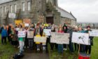 Members of the community stood outside Woodside Library on Clifton Road with signs to protest the closure of their local library. Image: Kath Flannery / DC Thomson.