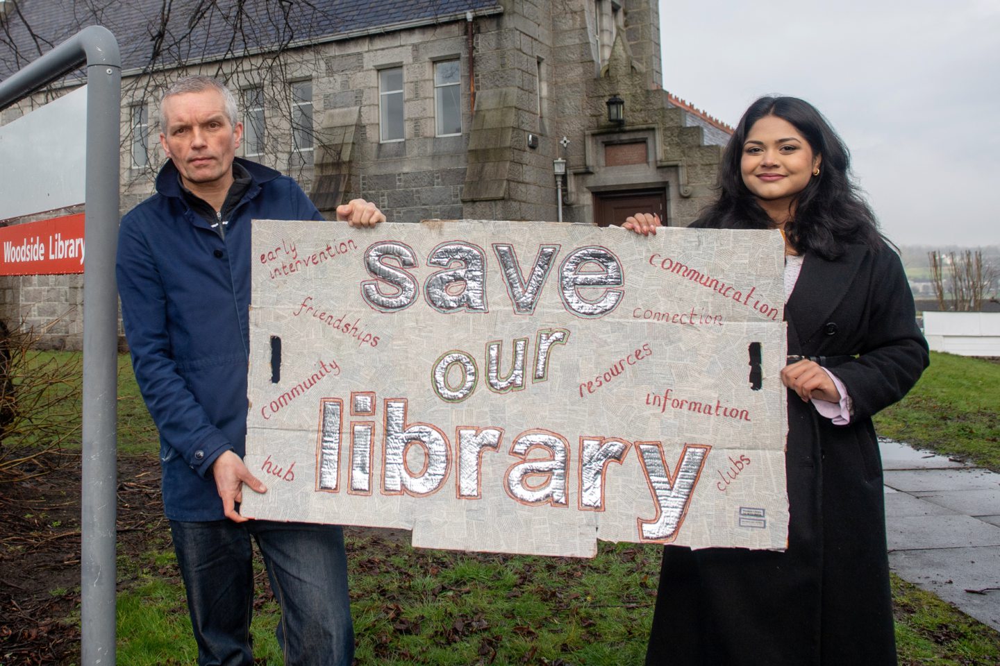 Campaigners in Aberdeen city holding a sign reading 'save our libraries'