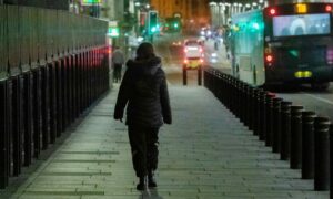 A woman walking on the street at night