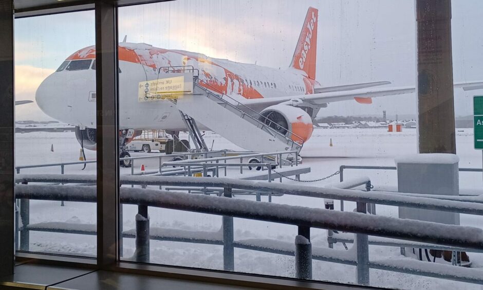 Plane standing out in the snow at Aberdeen airport