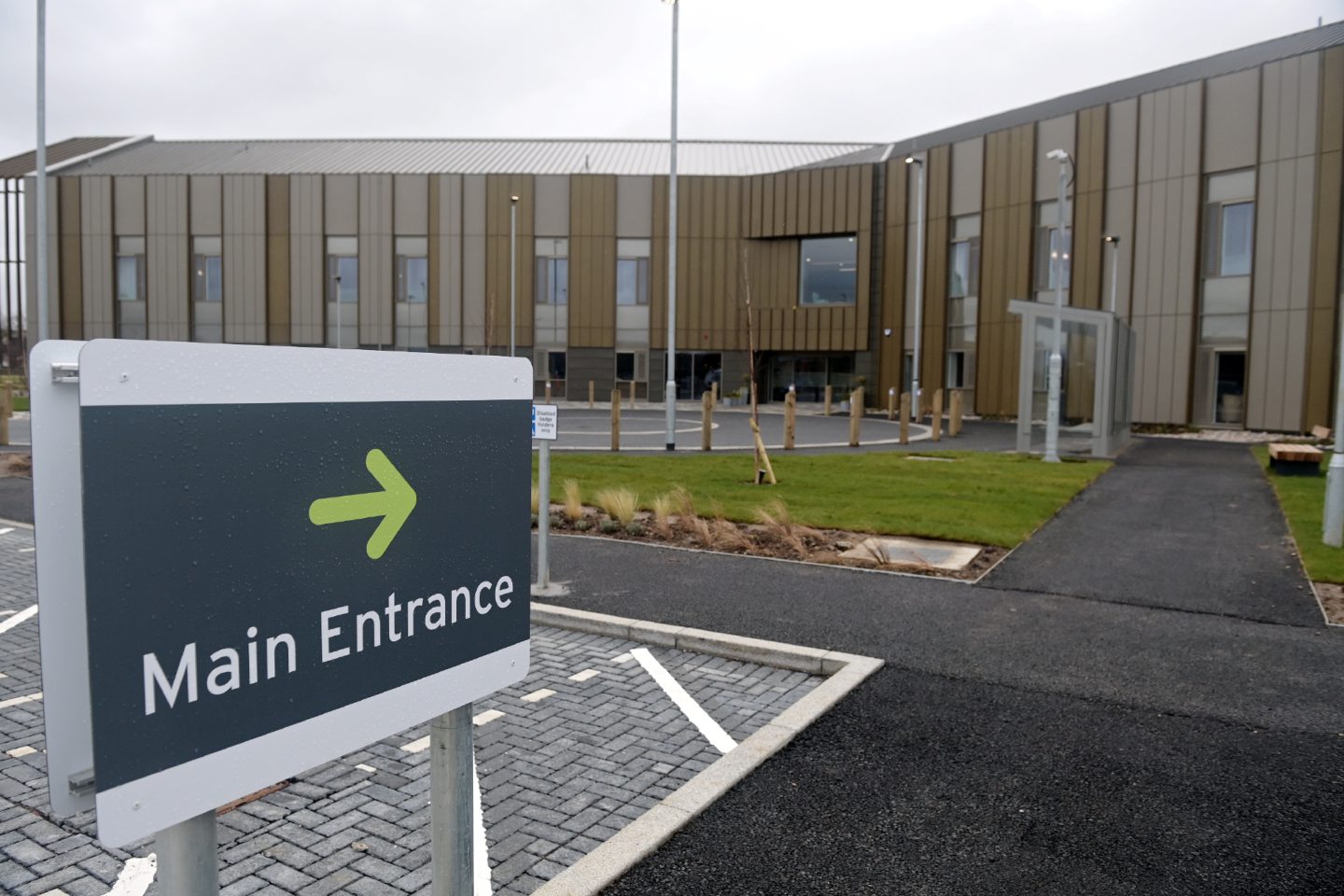 Exterior view of National Treatment Centre in Inverness with sign pointing to main entrance. 
