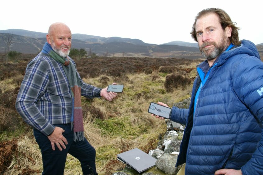 (L-R): Richard Drummond and Jon Erasmus holding mobile phones with Hop on them.