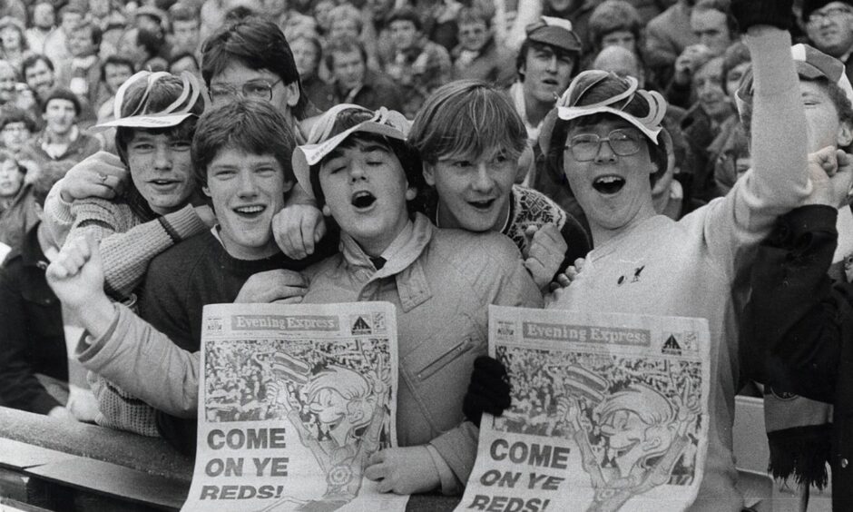 Come on ye reds ... young fans join the chant with their Euro Extra editions of the "Evening Express.". Image: DC Thomson.