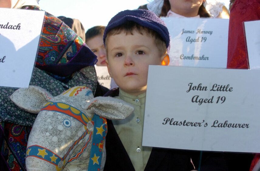 Children held aloft placards with the names of the victims during an event in 2005. Image: Raymond Besant.