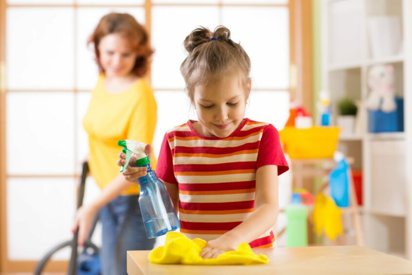 A mum helping her daughter clean her room. 