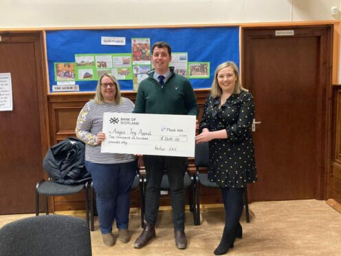 Andrew Adam and Lois Scott present the £2,600 cheque to Sheila Whitelaw of the Angus Toy Appeal.
