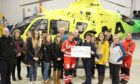 The committee presents the £2,000 cheque to Scotland's Charity Air Ambulance in Aberdeen.