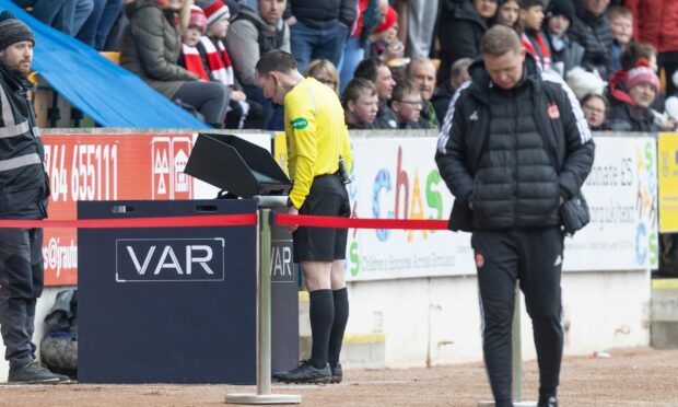 Referee Colin Steven checks the VAR screen before sending off Andy Considine. Image: Shutterstock.