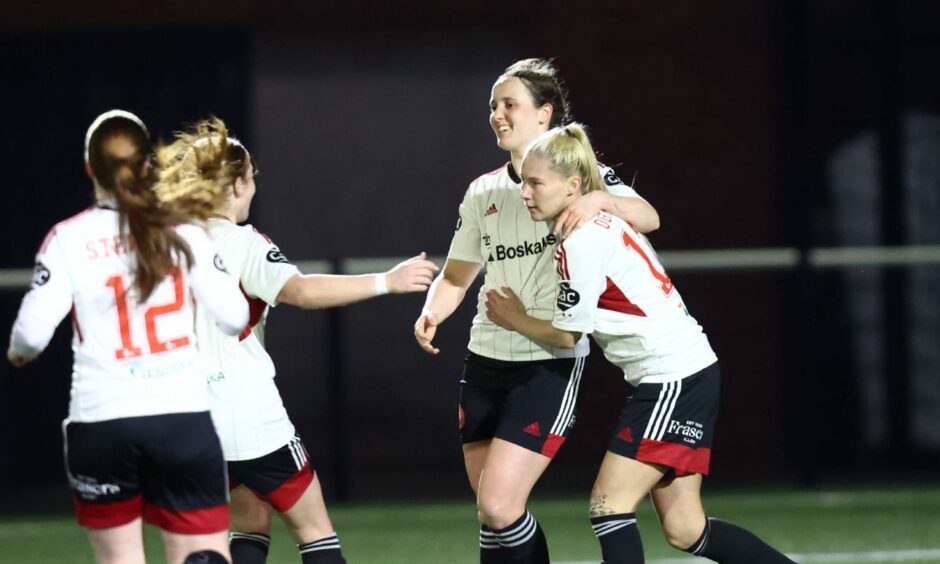 Aberdeen Women celebrate with Bayley Hutchison after she scored the winning goal against Dundee United at Gussie Park on 19 April.