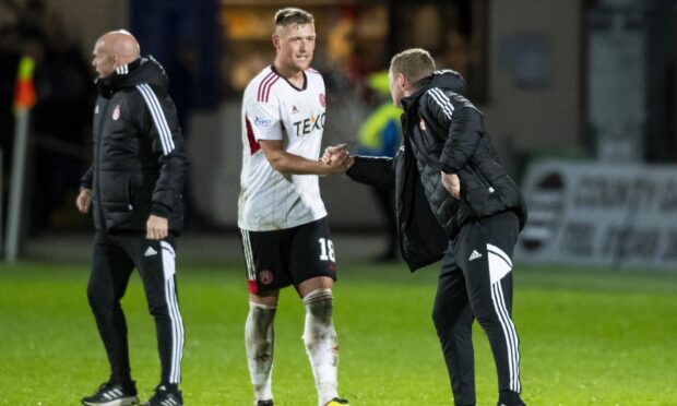 Aberdeen boss Barry Robson shakes hands with defender Mattie Pollock following the Dons' 1-0 win at Ross County. Image: SNS