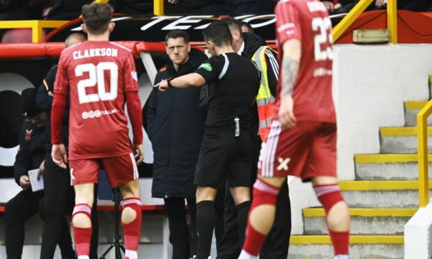 Referee Nick Walsh asks a member of Aberdeen staff for the ball boys to speed up during the Premiership match with Rangers. Image: SNS