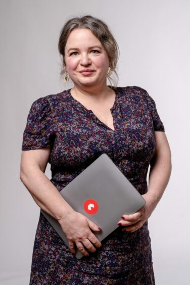 Firtha Lewin holding a laptop