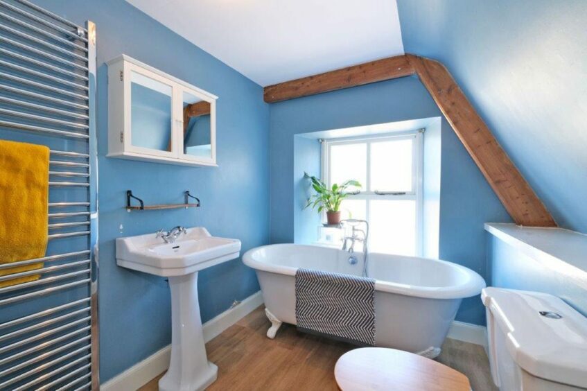 Family bathroom with free standing roll-top slipper bath with claw legs.