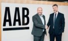 l-r AAB chief executive Graeme Allan shakes hands on a deal with French Duncan managing partner Graeme Finnie. Image: AAB