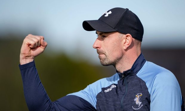 Skye Camanachd manager Kenny MacLeod holding his fist in the air