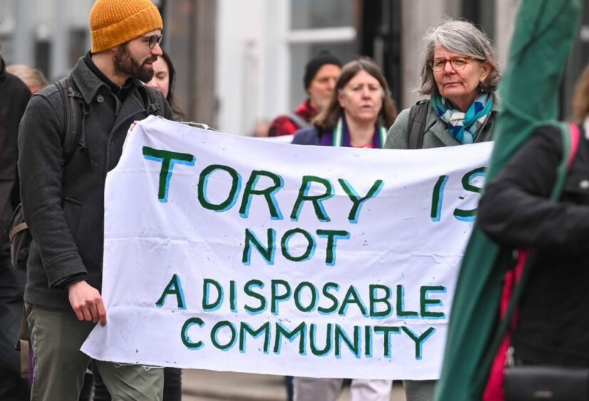 Campaigners hold a sign that says "Torry is not a disposable community". 