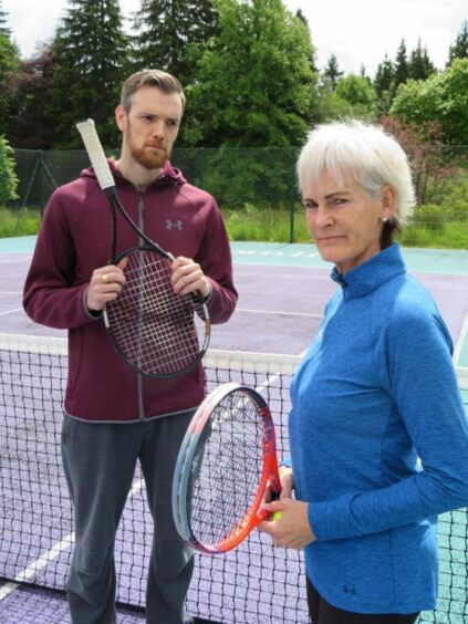 Judy Murray and Duncan Murray on the tennis court holding rackets.