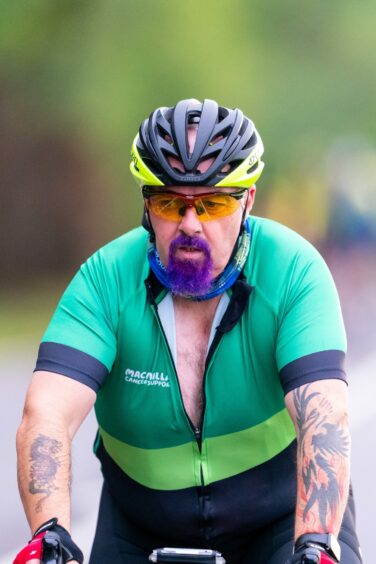 Cyclist at Etape Loch Ness wearing clothing with the Macmillan Cancer Support logo on it.