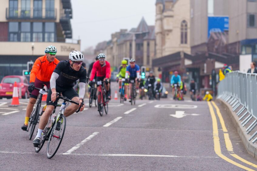Cyclists riding through street in Inverness.