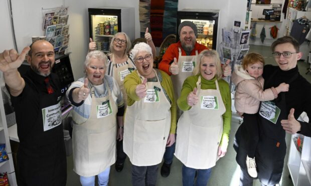 Celebrations from the team who will be running the Invermoriston Community Shop (left - right) Stephane Pilli , Stella Barter, Jackie Buckley, Hilary Wilson, Paul McIntosh, Lynne West and Julius Prakelis with his daughter, Renesme. Image Iain Ferguson.