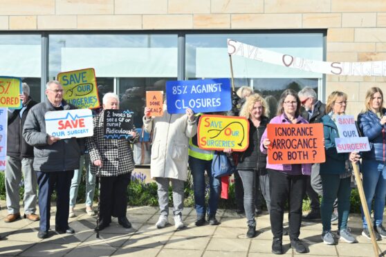 Members of the Save our Surgeries group take their grievances to Moray Coast Medical Practice earlier today. Images: Jason Hedges/DC Thomson
