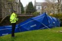Police are standing near to a cordoned off at Belmont Gardens where a body was found. Image: Kenny Elrick/DC Thomson.