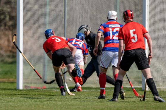 Kingussie number 14 James Falconer squeezes home the only goal of the game against Oban Camanachd. Image: Neil Paterson.