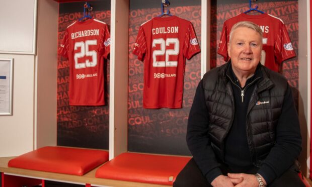 Aberdeen director Willie Garner sitting at the seat he used to occupy in the Pittodrie home dressing room during his playing career. Image: Kami Thomson/DC Thomson