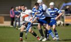 Newtonmore's Steven Macdonald takes charge against Lewis Tawse and Callum Cruden (both Lovat). Image: Neil Paterson.