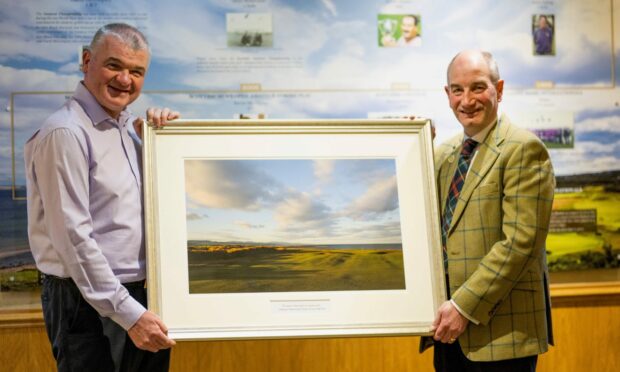 Royal Dornoch general manager Neil Hampton presents new honorary member Paul Lawrie with a framed print of the championship course. Image: Matthew Harris