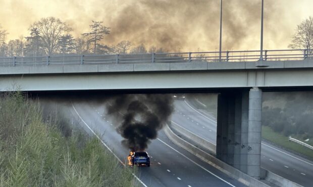 Image shows a dark SUV on fire just before the bridge carrying North Deeside road on the AWPR. Image: DC Thomson.