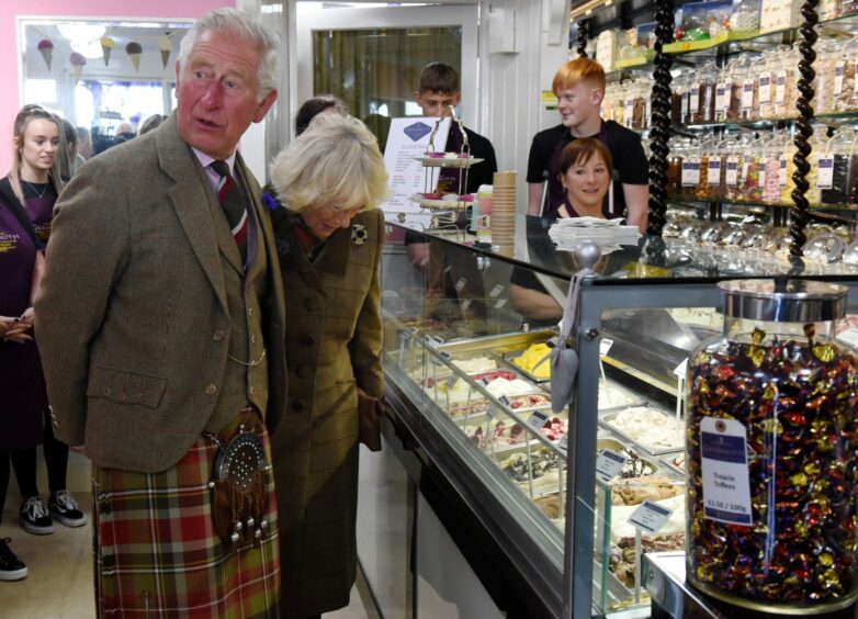 Charles looks around the shop while Camilla chooses an ice-cream with Marjory, right, behind the counter.
