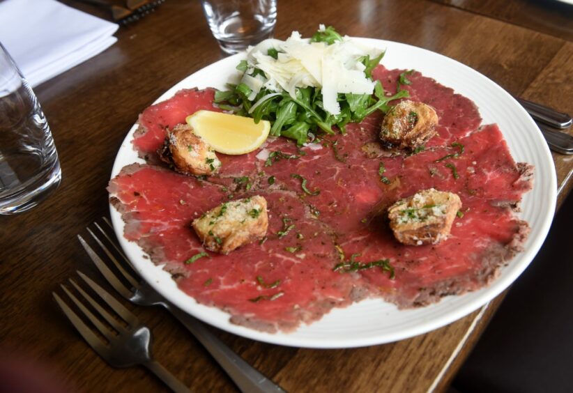 Scotch fillet of beef carpaccio with crisp fried artichokes, fresh rocket leaves and shaved manchego cheese with gremolata at Rocpool restaurant in Inverness