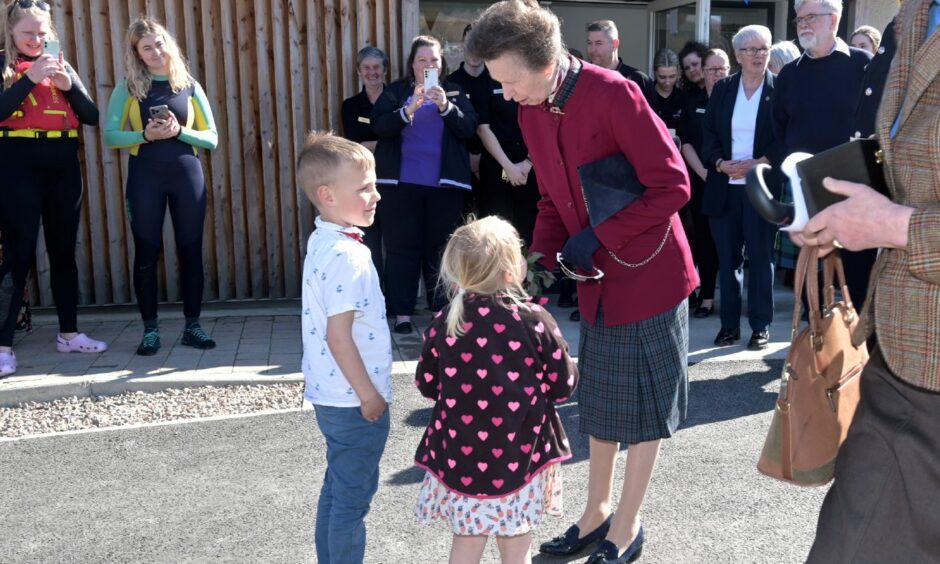 During her visit to Lochaber, Princess Anne meets Benji (6) and Ella (4) who present her with a bouquet of flowers.