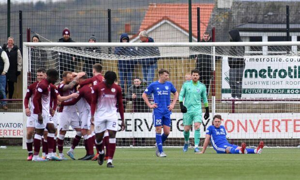 Peterhead co-manager Ryan Strachan looks dejected as Kelty celebrate their late winner which relegated the Blue Toon. Image: Duncan Brown.