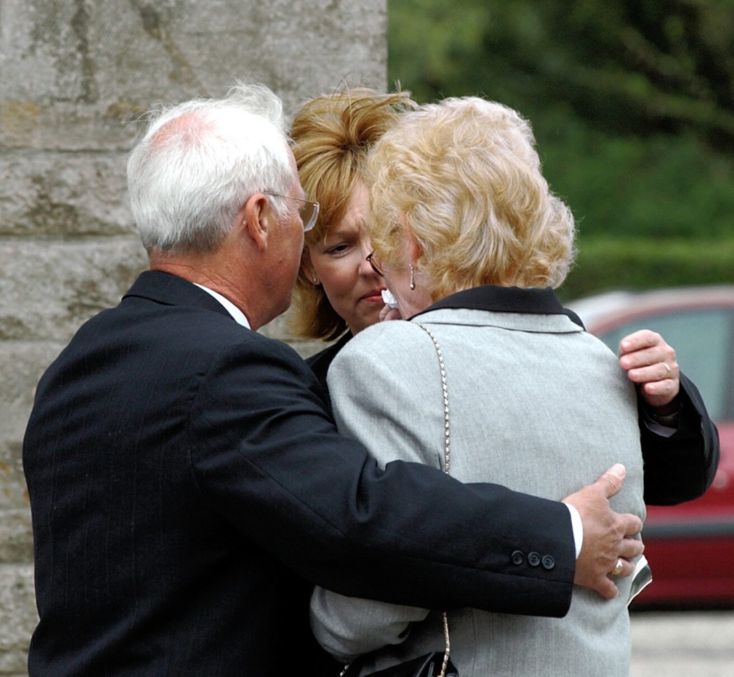 Arlene Fraser's family hug outside a church in Elgin where a memorial service was held. 