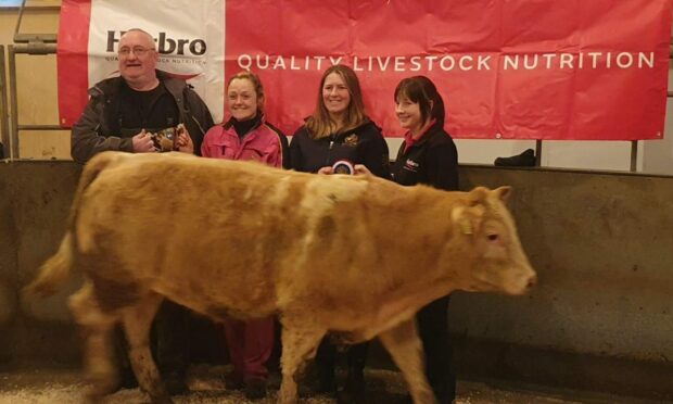 Aimee and Kirsty Budge receive the overall champion award from judge Eric Graham, with sponsors Harbro.