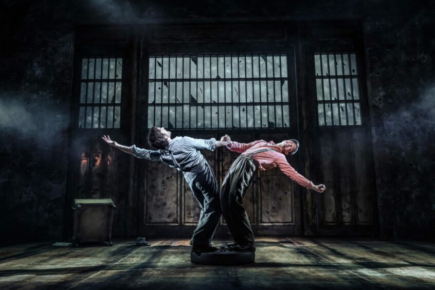 Photo of two performers dancing for Bonnie and Clyde in a dark backdrop. 