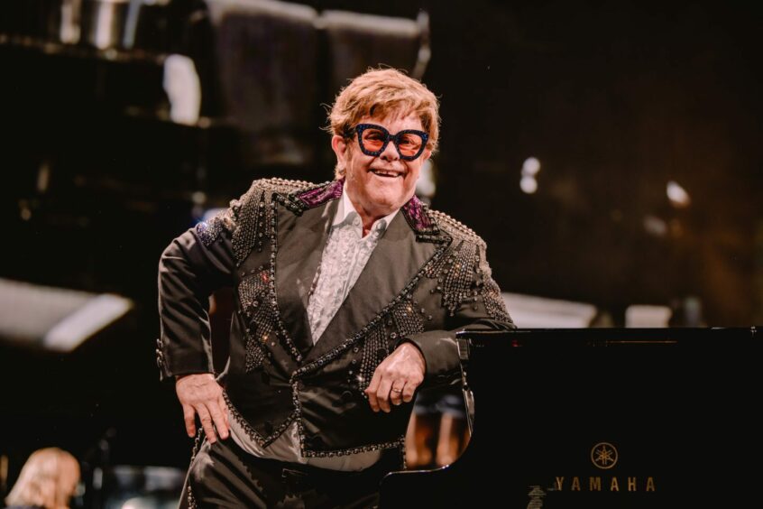 Elton John sitting at piano at his Liverpool concert in 2023.
