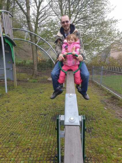 Iain MacVicar with their daughter Jessica on a seesaw. Image: Charli MacVicar.