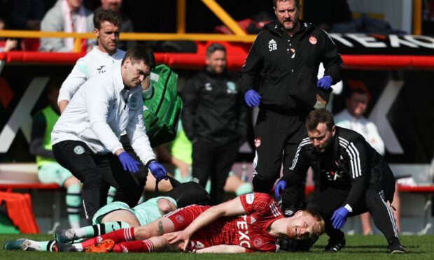 Both Hibs' Josh Campbell and Aberdeen's Liam Scales go down following a challenge. Image: SNS