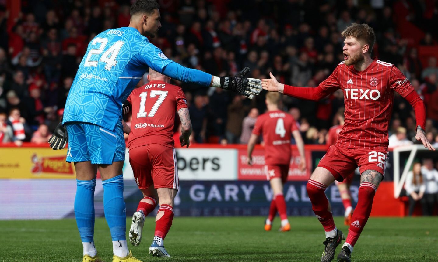 Aberdeen's Hayden Coulson celebrates with keeper Kelle Roos after he saved a penalty from Hibs' Kevin Nisbet. 