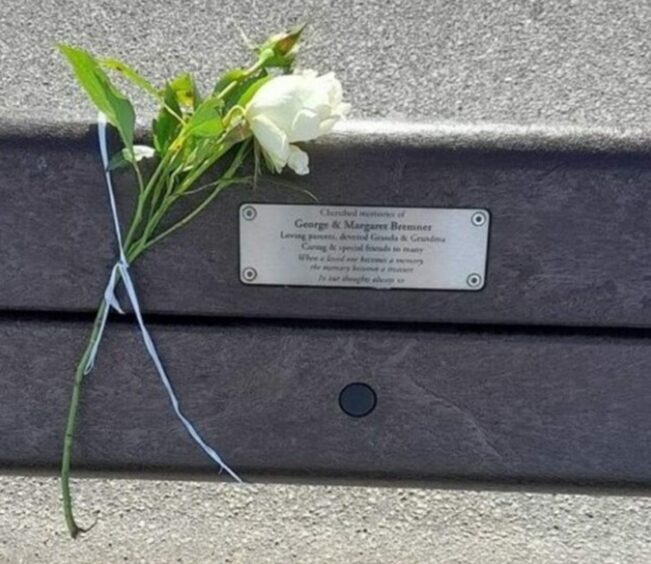 A white rose tied to George and Margaret Bremner's memorial bench