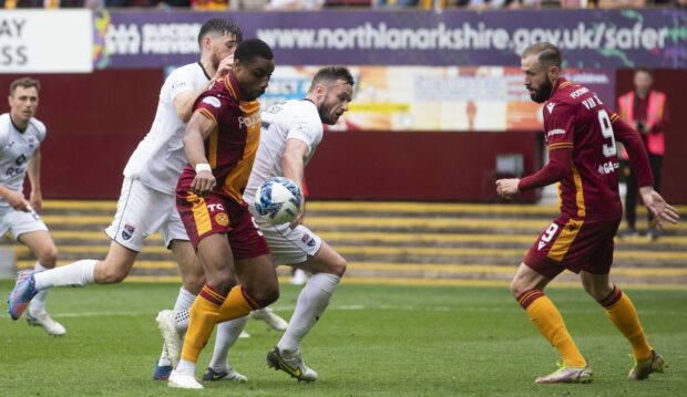 Ross County's Keith Watson handles the ball - which, after a VAR review, saw referee Alan Muir award a penalty which Kevin Van Veen scored to make it 1-0 Motherwell. Image: SNS