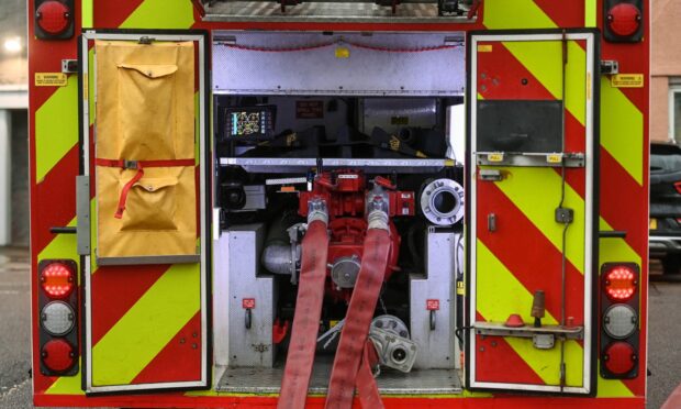 The back of a fire engine, hoses unrolled and ready to be used