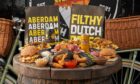 ABERDAM spread of fries and burgers on a wooden barrel table.