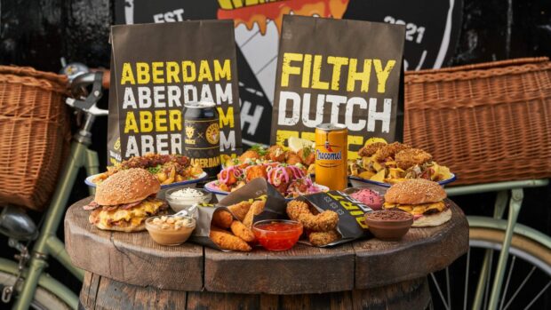 ABERDAM spread of fries and burgers on a wooden barrel table.